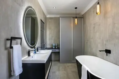 a bathroom with a tub and a sink and a mirror at Woman Era Guest House in Midrand