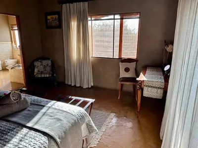 a bedroom with a bed and a window and a table at Luna Crescente 19 and 19A Zebula golf and spa resort 14 Pax Bela Bela Limpopo in Mabula