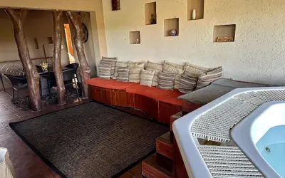 a living room with a red couch with pillows at Luna Crescente 19 and 19A Zebula golf and spa resort 14 Pax Bela Bela Limpopo in Mabula