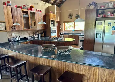 a kitchen with a large counter with chairs and a refrigerator at Luna Crescente 19 and 19A Zebula golf and spa resort 14 Pax Bela Bela Limpopo in Mabula