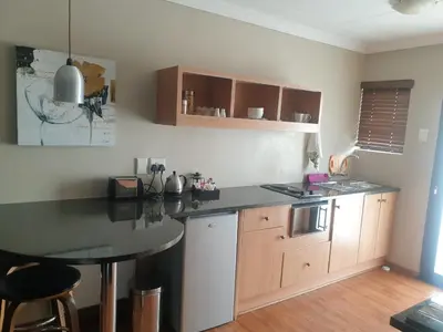 a kitchen with a table and a counter top at Perfek Stay Guesthouse in Secunda