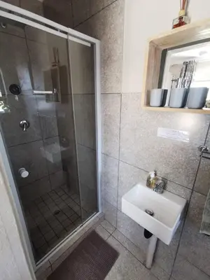 a bathroom with a shower and a sink at Sonador Bush House in Marloth Park