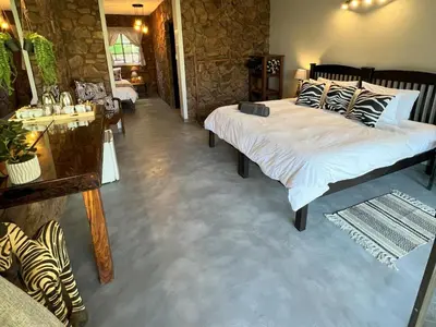 a bedroom with a large bed in a room at Ehlathini Game Lodge in Marken
