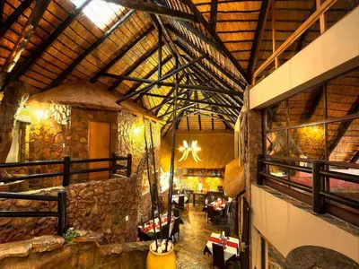a large room with a building with a stone wall at Ehlathini Game Lodge in Marken
