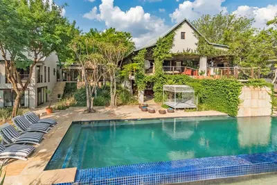 a swimming pool with chairs and a house at Luxurious Hideaway Villa in Midrand