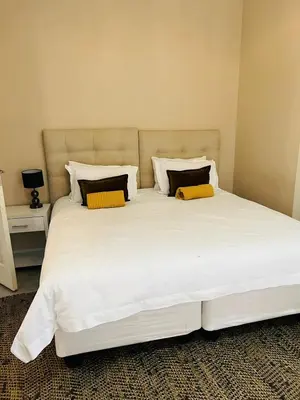 a large white bed with two pillows on it at Ultimate Sky-2 bedroom villa in Pretoria