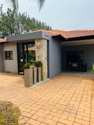 a house with a brick patio with a fireplace at Ultimate Sky _ 2 bedroom villa in Pretoria