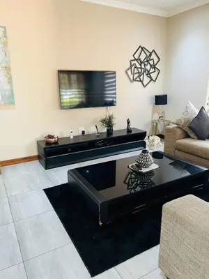 a living room with a couch and a tv at Ultimate Sky _ 2 bedroom villa in Pretoria