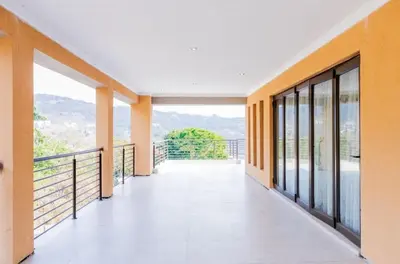 an empty corridor of a building with a balcony at TINDLOVU GUESTHOUSE in Nelspruit
