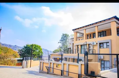 a building with a fence in front of it at TINDLOVU GUESTHOUSE in Nelspruit