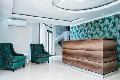 a lobby with two chairs and a reception desk at TINDLOVU GUESTHOUSE in Nelspruit
