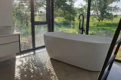 a white bath tub in a bathroom with a window at Lindi Lodge, Mjejane Game Reserve in Hectorspruit