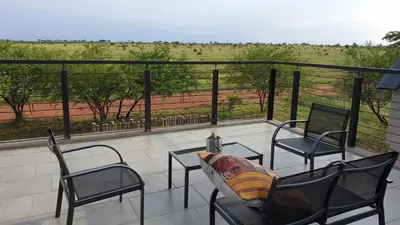 a balcony with chairs and a view of a field at Lindi Lodge, Mjejane Game Reserve in Hectorspruit