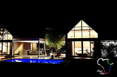 a large house with a blue pool in front of it at Lindi Lodge, Mjejane Game Reserve in Hectorspruit