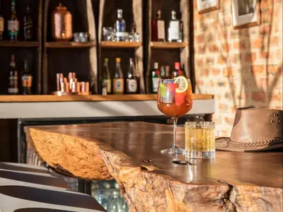 a bar with a drink on a wooden table at NAKO Safari Lodge in Dinokeng Game Reserve