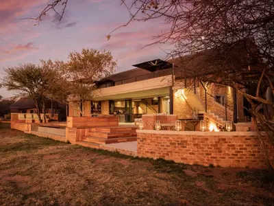 a brick house with a staircase leading up to it at NAKO Safari Lodge in Dinokeng Game Reserve