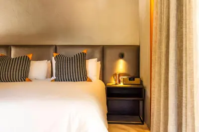 a bedroom with a bed and a lamp on a table at NAKO Safari Lodge in Dinokeng Game Reserve