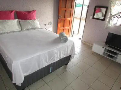 a bedroom with a large bed and a television at Next to Dinokeng in Hammanskraal Private property in Kekana