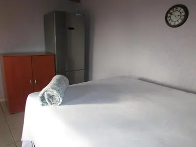 a bed in a room with a clock on the wall at Next to Dinokeng in Hammanskraal Private property in Kekana