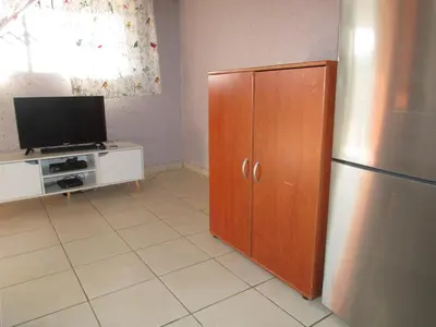 a kitchen with a refrigerator and a tv at Next to Dinokeng in Hammanskraal Private property in Kekana