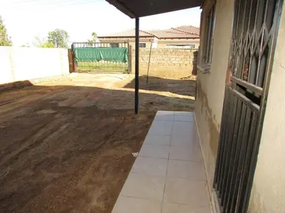a patio with an umbrella next to a building at Next to Dinokeng in Hammanskraal Private property in Kekana