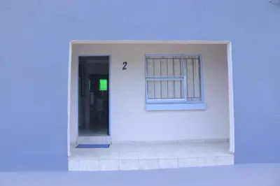 a white building with a door and a window at Lis ville guest house in Phalaborwa