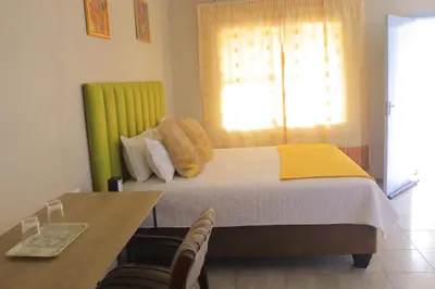 a bedroom with a bed with a yellow and white blanket at Lis ville guest house in Phalaborwa
