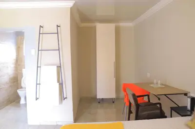 a dining room with a table and a ladder at Lis ville guest house in Phalaborwa