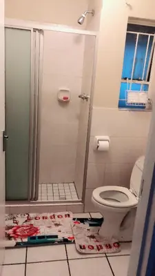 a bathroom with a toilet and a glass shower at Menlyn Bizcation Accommodation in Pretoria