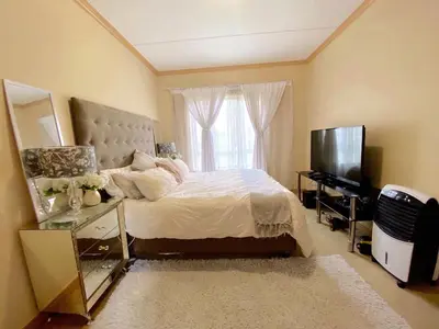 a bedroom with a bed and a television and a mirror at Siena Sun Luxury Suites in Erand
