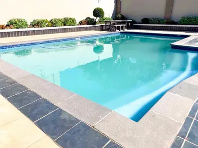 a swimming pool with blue water in a building at Siena Sun Luxury Suites in Erand