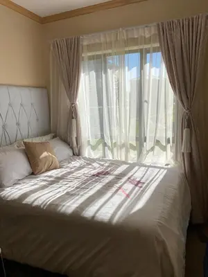 a bed in front of a window in a bedroom at Siena Sun Luxury Suites in Erand