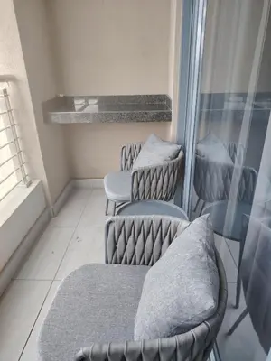 two chairs sitting in a room with a window at Menlyn Maine - The Trilogy Apartment 1111 in Pretoria