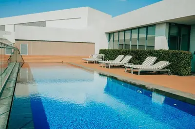 a swimming pool with lounge chairs and a building at Menlyn Maine - The Trilogy Apartment 1111 in Pretoria