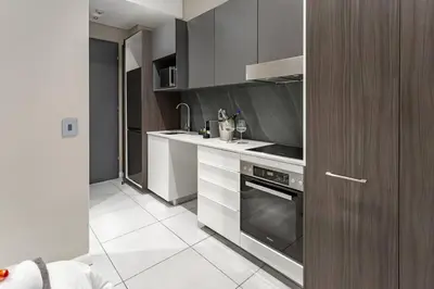a kitchen with a sink and a stove at Menlyn Maine - The Trilogy Apartment 1111 in Pretoria