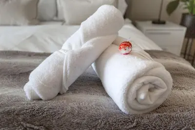a white towel laying on top of a bed at Menlyn Maine - The Trilogy Apartment 1111 in Pretoria