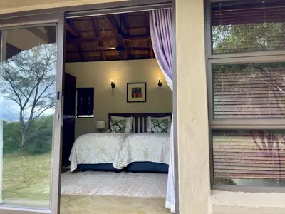 a bedroom with a bed and sliding glass doors at 213 Zebula Golf Estate & Spa - 4 Bedroom Home in Mabula