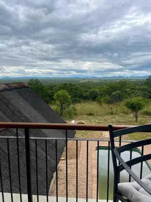 a balcony with a chair and a view of a field at 213 Zebula Golf Estate & Spa - 4 Bedroom Home in Mabula