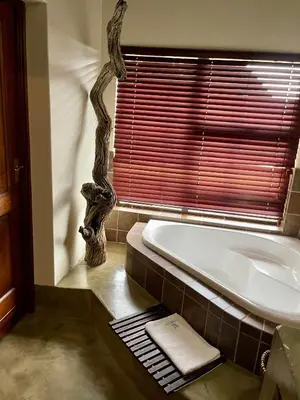 a bathroom with a bath tub and a window at 213 Zebula Golf Estate & Spa - 4 Bedroom Home in Mabula