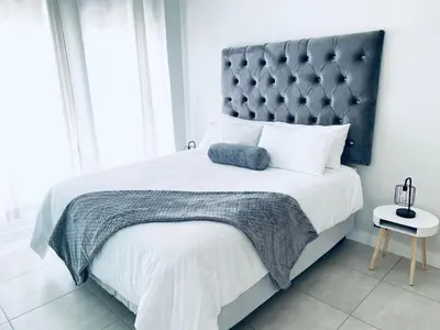 a bedroom with a large bed with a large headboard at The Blyde Crystal Lagoon Bliss in Pretoria
