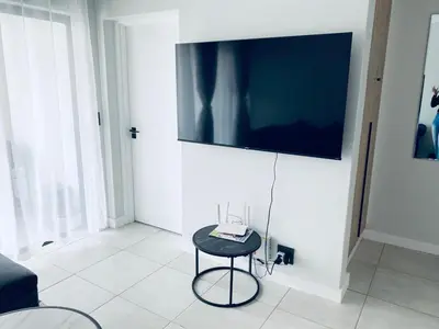 a room with a stool and a television on a wall at The Blyde Crystal Lagoon Bliss in Pretoria