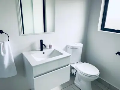 a white bathroom with a sink and a toilet at The Blyde Crystal Lagoon Bliss in Pretoria