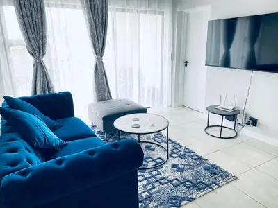 a living room with a blue couch and a table at The Blyde Crystal Lagoon Bliss in Pretoria