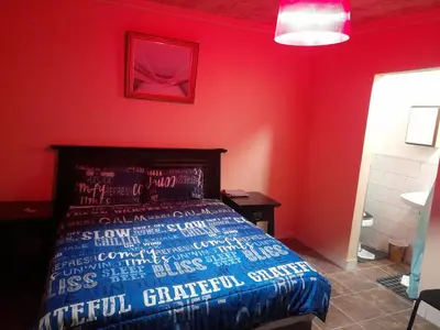 a bedroom with a bed in a red wall at Cozy guesthouse springs in Springs