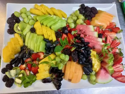 a white plate with a bunch of fruits and vegetables at Sambane Game Lodge in Bracondale