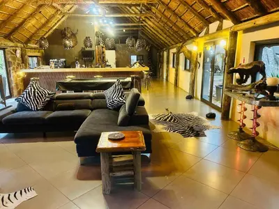 a living room with a couch and a table at Sambane Game Lodge in Bracondale
