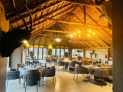a dining room with tables and chairs in a building at Sambane Game Lodge in Bracondale