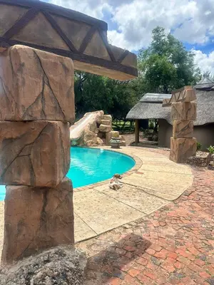 a pool in a backyard with a water slide at Sambane Game Lodge in Bracondale