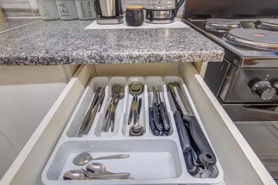 a kitchen drawer filled with utensils and a sink at Ovendales Self Catering Cottage in Benoni