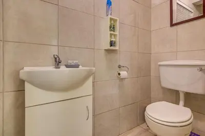 a bathroom with a toilet and a sink at Ovendales Self Catering Cottage in Benoni